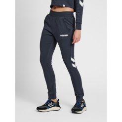 Damski stożkowy kombinezon do joggingu Hummel Legacy. Białe kombinezony Hummel, bez wzorów, z bawełny, sportowe, bez kołnierzyka, bez ramiączek. Za 191.00 zł.
