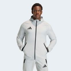 Kurtka piłkarska treningowa ADIDAS Tiro Travel 26. Brązowe kurtki adidas, m, bez wzorów, z materiału, eleganckie, z kapturem. Za 229.99 zł.