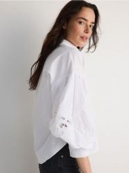 Koszula z ażurowymi rękawami - biały. Białe koszule Reserved, l, w ażurowe wzory, z bawełny, bez kołnierzyka, bez ramiączek. W wyprzedaży za 89.99 zł.