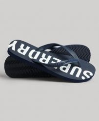 Superdry Code Core Sport Klapki gumowe – Eclipse Navy/Optic. Niebieskie klapki Superdry, bez wzorów, z gumy, sportowe, bez obcasa, bez zapięcia. Za 116.60 zł.