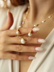 Pierres delicates Pozłacany naszyjnik z elementami ozdobnymi - dł. 50 cm rozmiar: onesize. Białe naszyjniki Pierres delicates, z materiału, z perłą, pozłacane. Za 86.99 zł.