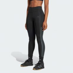 Długie legginsy Optimé 3-Stripes. Czarne legginsy adidas, bez wzorów, długie. W wyprzedaży za 235.80 zł.