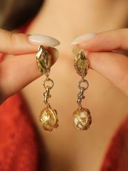 Pierres de Jade Pozłacane kolczyki-wkrętki z perłami rozmiar: onesize. Brązowe kolczyki Pierres de Jade, z perłą, pozłacane. Za 30.99 zł.