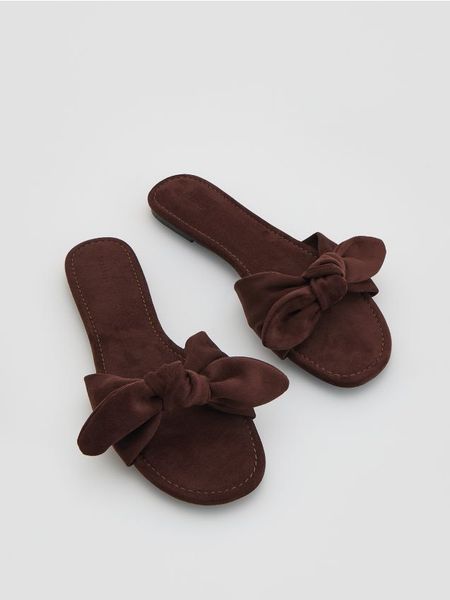 Klapki z kokardami - ciemnobrązowy. Brązowe klapki Reserved, bez wzorów, bez obcasa, bez zapięcia. Za 119.99 zł.