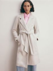 Płaszcz z wiązaniem - kremowy. Białe płaszcze Reserved, l, bez wzorów, z tkaniny, klasyczne, bez kaptura. W wyprzedaży za 69.99 zł.