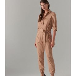 Kombinezon w stylu utility - Beżowy. Brązowe kombinezony Mohito, bez wzorów, bez kołnierzyka, bez ramiączek. Za 199.99 zł.