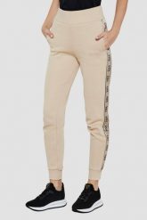 GUESS Beżowe spodnie dresowe damskie Britney. Brązowe spodnie dresowe Guess, z aplikacjami, z dresówki. W wyprzedaży za 284.99 zł.