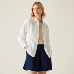 Koszula turystyczna damska Primevere. Białe koszule Regatta, bez wzorów, z bawełny, bez kołnierzyka, bez ramiączek. W wyprzedaży za 216.00 zł.