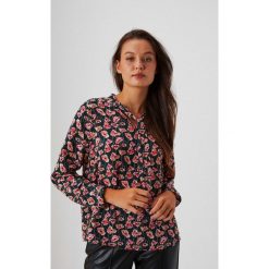Koszula w kwiaty z ozdobnym dekoltem. Zielone koszule MOODO, m, bez wzorów, z poliesteru, bez kołnierzyka, bez ramiączek. W wyprzedaży za 49.99 zł.