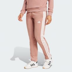Spodnie Essentials 3-Stripes French Terry Cuffed. Białe spodnie dresowe adidas, bez wzorów, z materiału. W wyprzedaży za 127.02 zł.