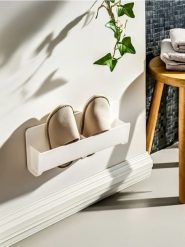 Ścienny uchwyt na kapcie - biały. Białe kapcie Sinsay, bez wzorów. Za 15.99 zł.