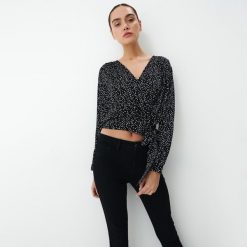Kopertowa bluzka w kropki - Czarny. Czarne bluzki Mohito, bez wzorów, bez kołnierzyka, bez ramiączek. W wyprzedaży za 49.99 zł.
