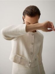 Krótki żakiet z tkaniny boucle - złamana biel. Marynarki i żakiety Reserved, l, bez wzorów, z bawełny, bez ramiączek. W wyprzedaży za 119.99 zł.