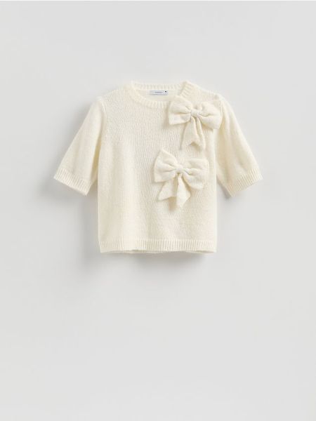 Sweter z kokardami - kremowy. Białe swetry Reserved, l, bez wzorów, z dzianiny, bez ramiączek. Za 129.99 zł.