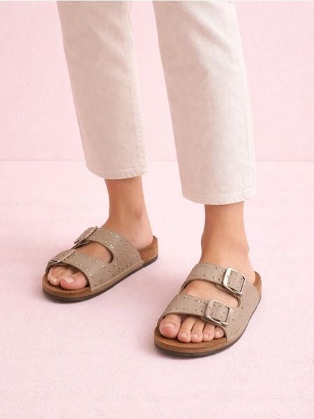 Klapki z ćwiekami i klamrami - beżowy. Brązowe klapki Sinsay, bez wzorów, bez obcasa, bez zapięcia. Za 49.99 zł.
