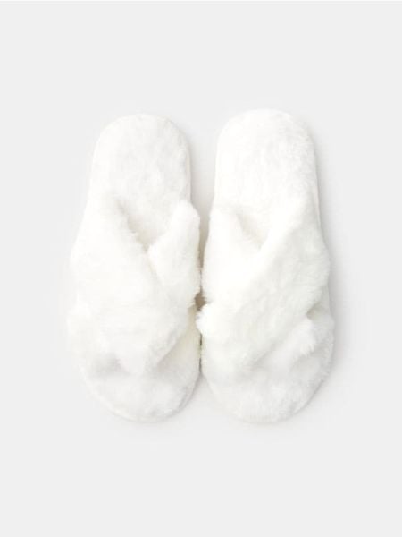 Kapcie ze sztucznym futrem - kremowy. Białe kapcie Sinsay, bez wzorów. Za 25.99 zł.