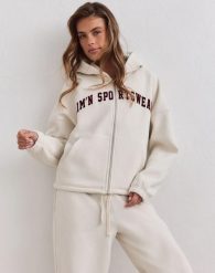 Damska bluza zapinana na zamek z kapturem Varsity kremowa. Białe bluzy AIM'N, l, bez wzorów, z bawełny, z kapturem, na fitness i siłownię. Za 388.00 zł.