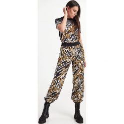 Spodnie dresowe VERSACE JEANS COUTURE. Spodnie dresowe Versace Jeans Couture, bez wzorów, z dresówki. W wyprzedaży za 982.17 zł.