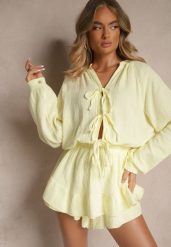 Żółty Kombinezon z Bawełny Ozdobiony Wiązaniem i Falbankami Nalelia. Żółte sukienki Renee, na co dzień, bez wzorów, z bawełny, eleganckie, bez kołnierzyka, bez ramiączek, kopertowe. W wyprzedaży za 151.99 zł.
