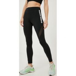Guess legginsy damskie kolor czarny z nadrukiem. Czarne legginsy Guess, z aplikacjami, ze skóry. Za 319.99 zł.
