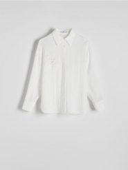 Koszula z ozdobną aplikacją - biały. Białe koszule Reserved, l, z aplikacjami, z tkaniny, bez kołnierzyka, bez ramiączek. Za 149.99 zł.