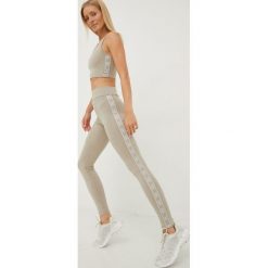 Guess legginsy damskie kolor beżowy z nadrukiem. Brązowe legginsy Guess, z aplikacjami. W wyprzedaży za 224.99 zł.
